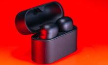 sony xm6 earbuds in charging case on red background