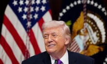 President Trump grimaces in front of a U.S. flag.