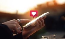 Young woman receiving notifications and commenting on social media posts with smart phone. People networking with technology. Social media addiction concept.