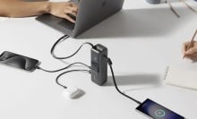anker laptop charger on table with several devices plugged into it