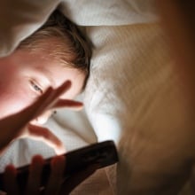 A child scrolls on a smartphone.