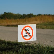 A sign stuck in the grass alongside a rural road. The sign reads "no data center."