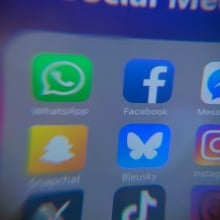 blurry social media icons on iphone screen with Bluesky app in center
