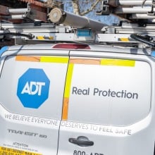 Logo for security company ADT on installation van parked on street
