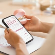woman holding phone with save the date on screen