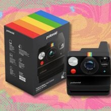 polaroid now+ 3rd generation i-type instant film camera against a yellow, pink and green patterned background