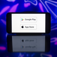 google play and apple app store logos on smart phone