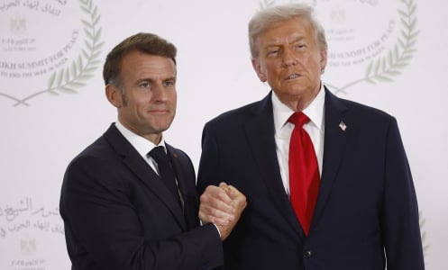 French President Emmanuel Macron (L) and US President Donald Trump (R) shake hands during the greetings ceremony at the Gaza Peace Summit