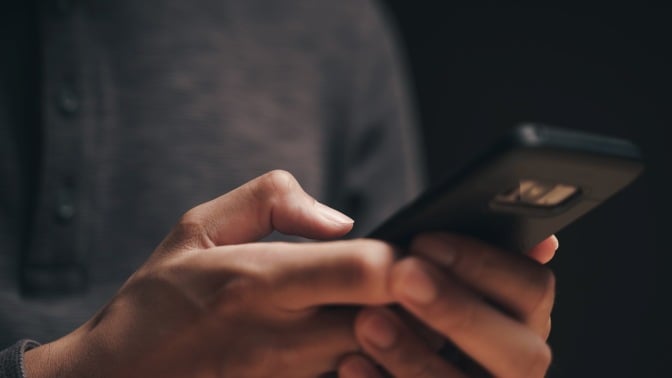 Closeup of a man using a smartphone in the dark