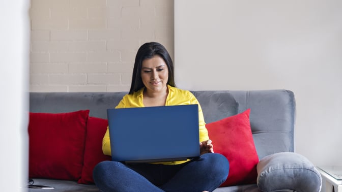 woman sitting on a couch with a laptop
