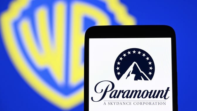 A phone with the Paramount logo against a backdrop of the Warner Bros. logo.