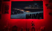 "Game of Thrones" scene on wall-mounted TCL QM6K TV with red light glowing around edges