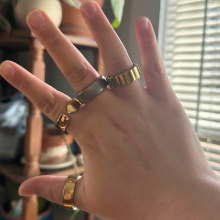 A person wearing four smart rings on one hand.