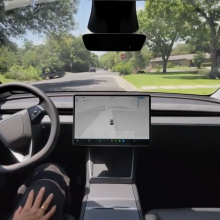 Inside a Tesla, a driver uses Full Self Driving.