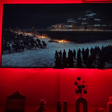 "Game of Thrones" scene on wall-mounted TCL QM6K TV with red light glowing around edges